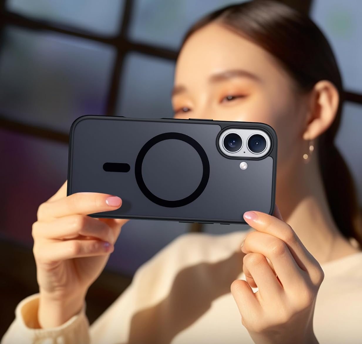 A woman framing a photo with an iPhone 17 in a black SPIDERCASE matte case
